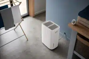 Buanderie aérée avec un déshumidificateur maison portable près d’un étendoir à linge