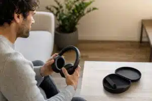 casque bluetooth meilleur rapport qualité prix : personne comparant un casque audio sans fil confortable dans un salon lumineux