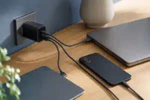 chargeur multi port usb c : chargeur USB-C multiport relié à plusieurs appareils sur un bureau lumineux